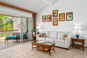 ein Wohnzimmer mit einem Sofa und einem Tisch in der Unterkunft "Makani Moana" at Keauhou Resort #104, Entire townhome close to Kona in Kailua-Kona