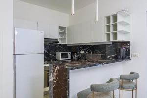 a kitchen with white cabinets and marble counter tops at Luna 2-BR in Mar Mikhael in Beirut