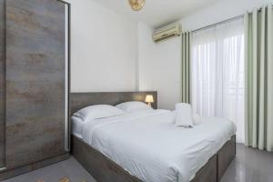 a bedroom with a large bed and a large window at Luna 2-BR in Mar Mikhael in Beirut