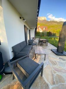patio con divano, tavolo e vista di La Cadamale a Menthon-Saint-Bernard