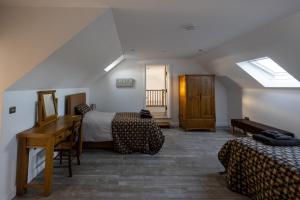 a bedroom with two beds and a desk in a room at 'Sgubor in Menai Bridge