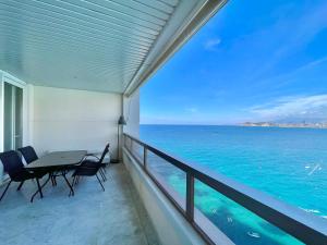 a balcony with a table and chairs and the ocean at Gemelos 28 Blueline in Benidorm