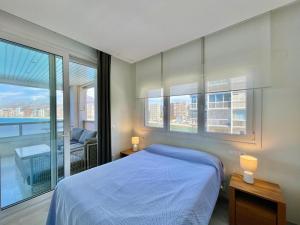 a bedroom with a blue bed and a balcony at Gemelos 28 Blueline in Benidorm