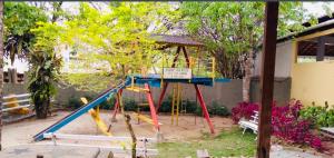 un parque infantil con columpio en un patio en Alugamos para grupos, en Vargem Alta