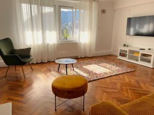 ein Wohnzimmer mit Sofa, Tisch und Fernseher in der Unterkunft Cloos - Elegant Residence with Panoramic View in Braşov