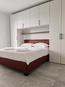 莫利亞諾威尼托的住宿－Appartamento Aura，一间卧室配有一张带白色橱柜的大床