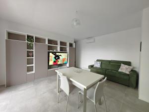 莫利亞諾威尼托的住宿－Appartamento Aura，客厅配有桌子和绿色沙发