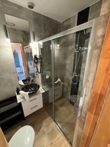 a bathroom with a glass shower and a sink at Willa Gościnny Próg in Krościenko