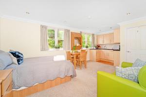 a bedroom with a bed and a table and a kitchen at Park Views Apartments in Teddington