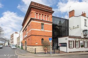 a brick building on the corner of a street at Strozzi Palace Suites by Mansley in Cheltenham