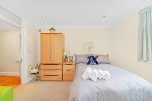 a bedroom with a bed with two towels on it at Park Views Apartments in Teddington