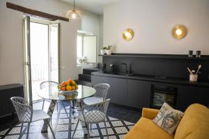 a living room with a couch and a table and chairs at La Marina - Casa Assuntina in Letojanni