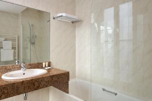 a bathroom with a sink and a shower at Régence Etoile in Paris