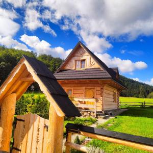 une petite maison en bois avec une clôture en bois dans l'établissement Domek Trzy Doliny Zakopane, Three Valleys Chalet with Jacuzzi, à Zakopane