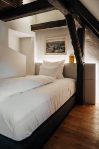 a bedroom with a large bed with white sheets at Bootshaus Amberg in Amberg