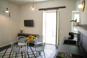 a kitchen with a table with a bowl of fruit on it at La Marina - Casa Assuntina in Letojanni