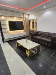 Cozy Residence Abuja في أبوجا: غرفة معيشة مع أريكة وطاولة قهوة