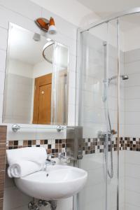 W łazience znajduje się umywalka oraz prysznic z lustrem. w obiekcie Koliba Hubertka w mieście Oravice