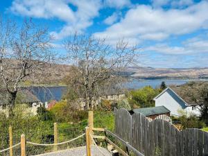 a wooden fence with a view of a body of water at Thistle Cottage in Fort William