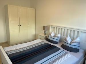 a bedroom with a bed with blue and white pillows at Haus Meeresbrise in Grömitz