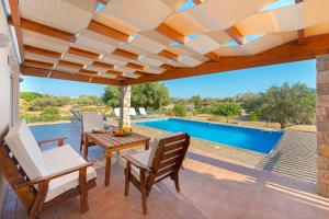 a patio with a table and chairs and a swimming pool at Olive Private Villa up to 12 in Kolymbia