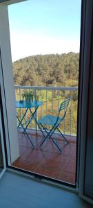 een blauwe tafel op een balkon met een palmboom bij Casa Carmen As Airas in Ourense