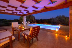 a patio with a table and chairs and a swimming pool at Olive Private Villa up to 12 in Kolymbia