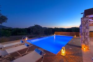 a swimming pool in a backyard at night at Olive Private Villa up to 12 in Kolymbia