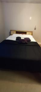 a bedroom with a large bed with a black blanket at Picon Homey in Springfield
