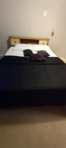 a bedroom with a large bed with a black blanket at Picon Homey in Springfield