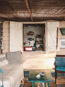 Habitación con ventana, sofá y mesa. en La Cabane du Pecheur, en Rivière Noire