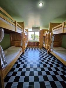 a room with bunk beds and a checkered floor at The 60 in George Town