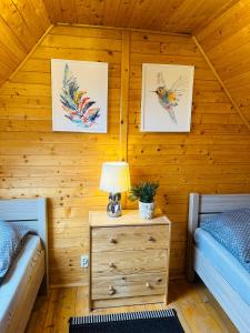 a bedroom with two beds and a table with a lamp at Dolina Bella in Gołubie