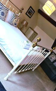 a bedroom with a white bed with a metal frame at The Cornishman Inn in Tintagel