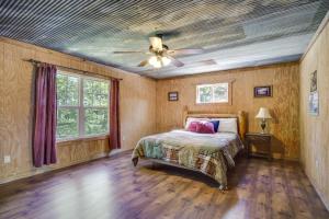 Heflin的住宿－River Bend Lodge Heflin Home in the Woods!，一间卧室配有一张床和吊扇