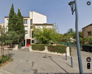un edificio con una puerta roja en una calle en Le Rubis - Zenith, en Toulouse