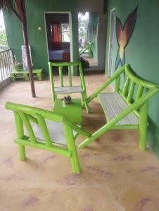 Dos sillas verdes sentadas en una habitación en Cabañas Raysa y Alejandro Pasion #3, en Las Galeras