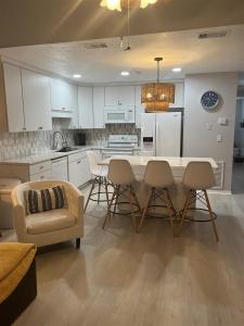 a kitchen with white cabinets and a table and chairs at Isle Be Back in Destin