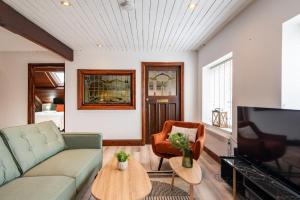 a living room with a couch and a tv at Madison House - Converted Church 5 Bed Pontypool in Pontypool