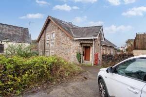 a white car parked in front of a brick house at Madison House - Converted Church 5 Bed Pontypool in Pontypool