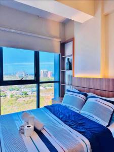 Punta EngañoにあるAmazing Sea View at Mactan Newtownの大きなベッドと大きな窓のある寝室