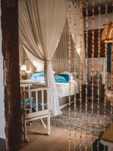 sypialnia z łóżkiem z baldachimem i niebieskimi poduszkami w obiekcie La Cabane du Pecheur w mieście Black River
