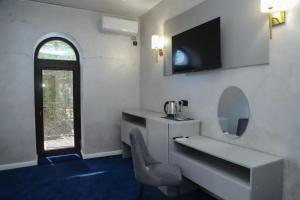 uma casa de banho com um lavatório, um espelho e uma cadeira em Central hotel em Meghri