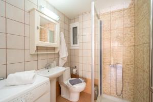 a bathroom with a toilet and a sink and a shower at Anna's Cozy Home in Argostoli +17 photos