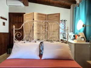 a bed with a metal headboard and two pillows at Garden's House in Spata +36 photos