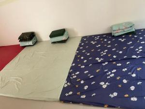 Una cama con un edredón azul con flores. en nhà hưng hà, en Dien Bien Phu