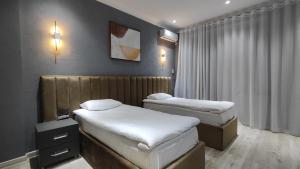 um quarto com duas camas num quarto em Calipso Dushanbe Hotel em Dushanbe