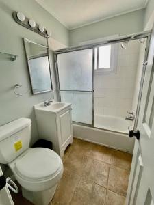 La salle de bains est pourvue de toilettes, d'un lavabo et d'une douche. dans l'établissement Cathedra 3l-Charming Apartment walk to UNMC, à Omaha