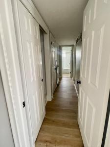 - un couloir avec des portes blanches et du parquet dans l'établissement Cathedra 3l-Charming Apartment walk to UNMC, à Omaha