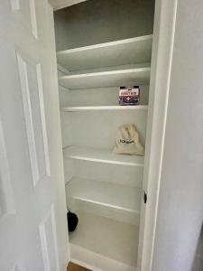 a closet with white shelves and a box of milk at Cathedra 3l-Charming Apartment walk to UNMC in Omaha